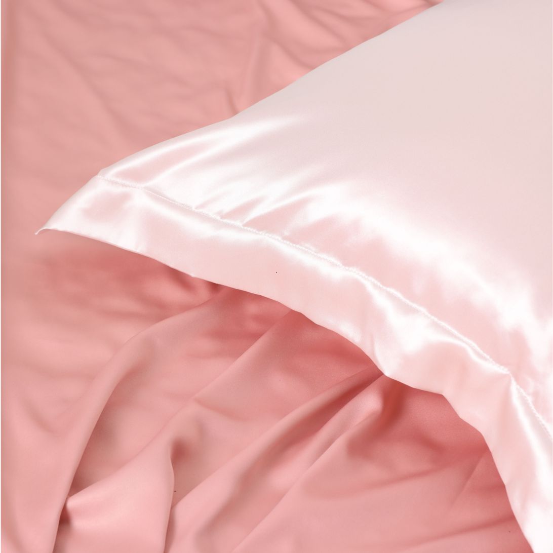 Roze zijden kussen(sloop) op roze beddengoed
